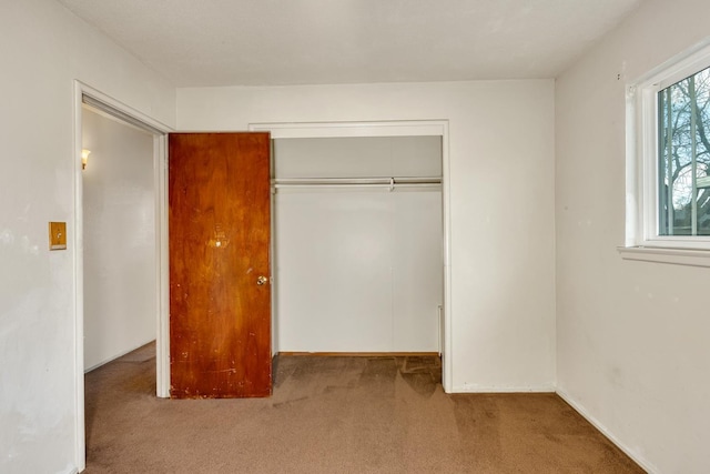 unfurnished bedroom with a closet and carpet flooring