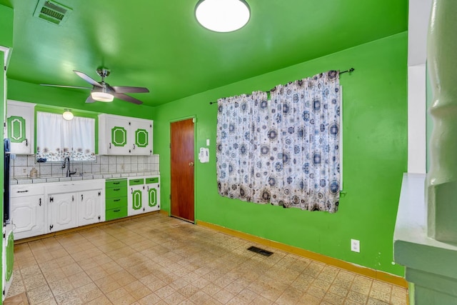 kitchen with white cabinetry, tile counters, visible vents, and decorative backsplash