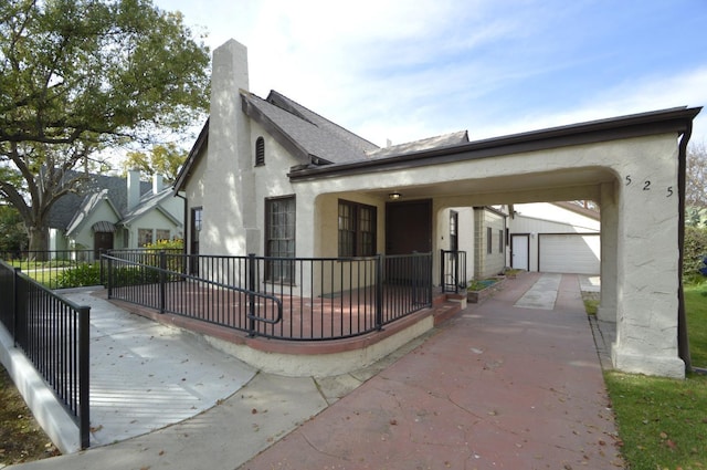 view of front facade featuring fence, a shingled roof, a chimney, an outdoor structure, and stucco siding