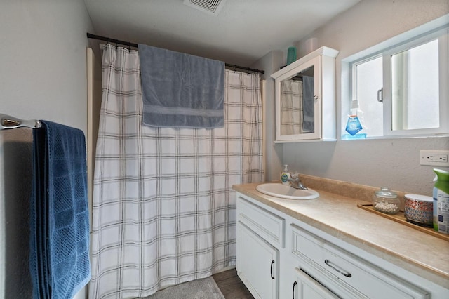 bathroom featuring visible vents, a shower with curtain, wood finished floors, and vanity