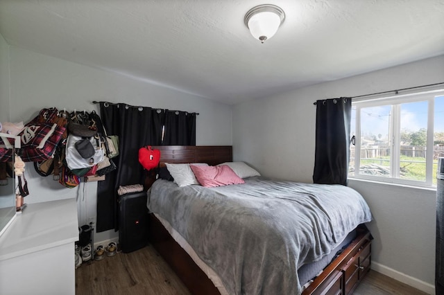 bedroom with baseboards and wood finished floors