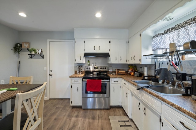 1301 Orange Ave, Chowchilla, CA 93610 - kitchen with stainless steel electric range, under cabinet range hood, a sink, white cabinetry, and dark wood finished floors
