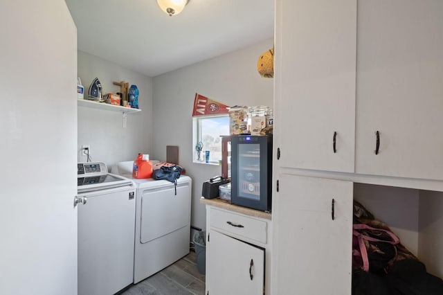 laundry area featuring cabinet space, washing machine and dryer, and light wood-style floors