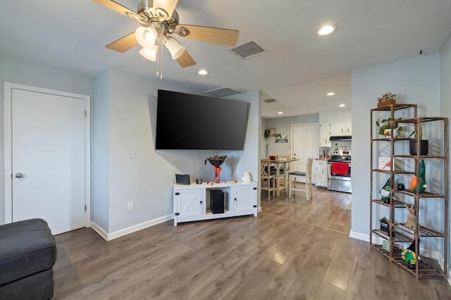 living area with recessed lighting, wood finished floors, and visible vents