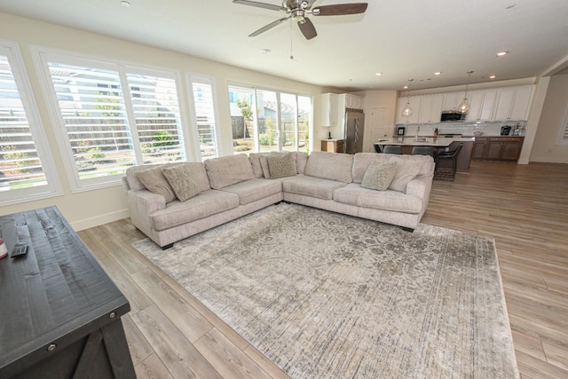 living room with recessed lighting, baseboards, light wood-type flooring, and ceiling fan