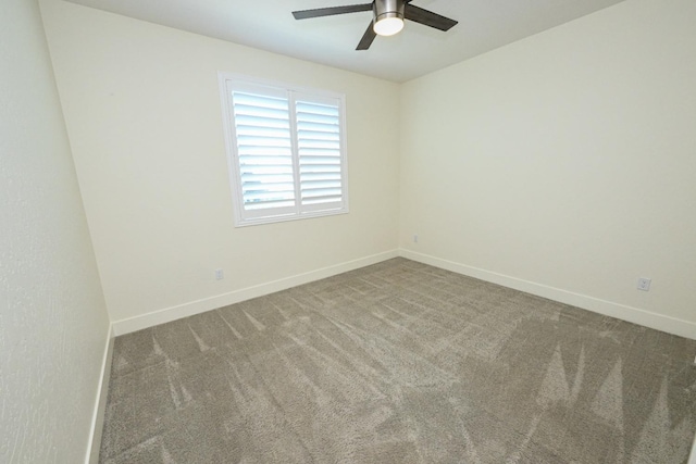 carpeted spare room with ceiling fan and baseboards