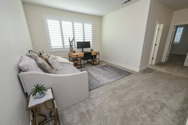 carpeted living room with visible vents and baseboards