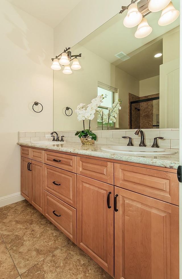 bathroom with a sink, visible vents, walk in shower, and double vanity