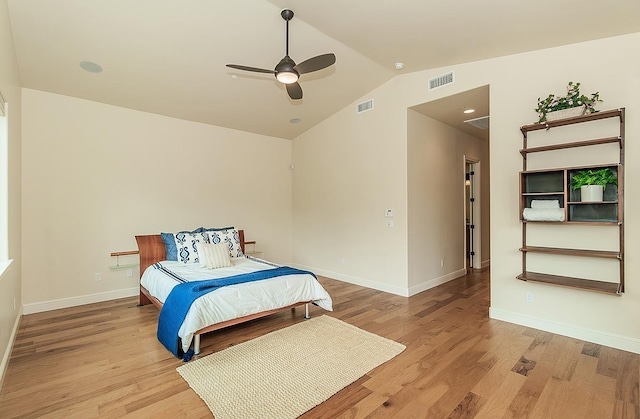 bedroom with light wood-type flooring, visible vents, baseboards, and vaulted ceiling