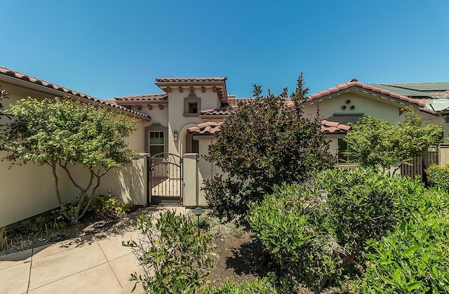 1562 N Empire Ln, Clovis, CA 93619 - view of front of property with a gate, a tiled roof, and stucco siding