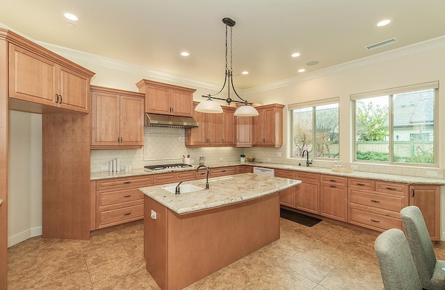 kitchen with gas cooktop, visible vents, a kitchen island with sink, a sink, and under cabinet range hood