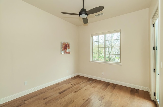 spare room featuring visible vents, light wood-style flooring, and baseboards