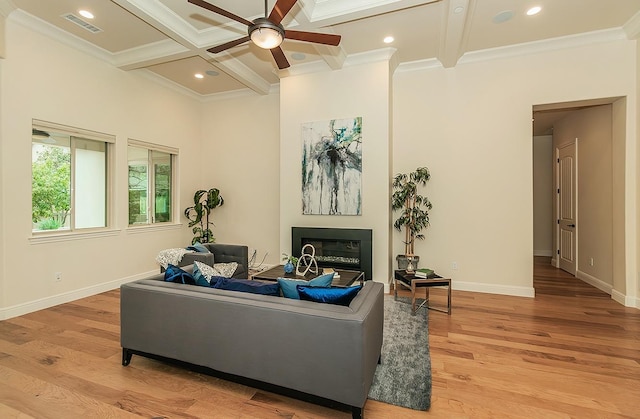 living room with beamed ceiling, coffered ceiling, a glass covered fireplace, light wood finished floors, and baseboards