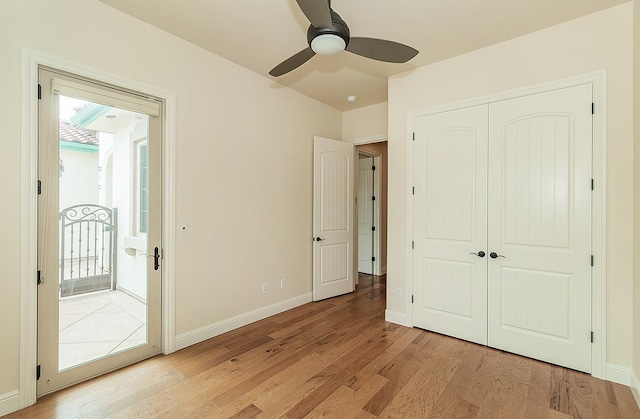 unfurnished bedroom featuring light wood-style flooring, access to exterior, a closet, baseboards, and ceiling fan