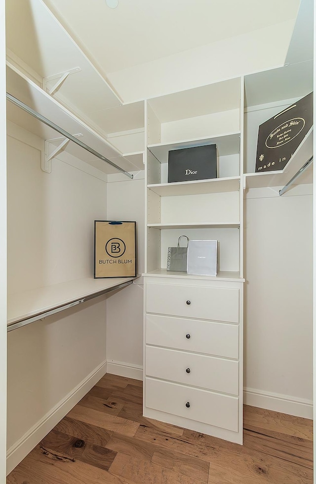 walk in closet with wood finished floors