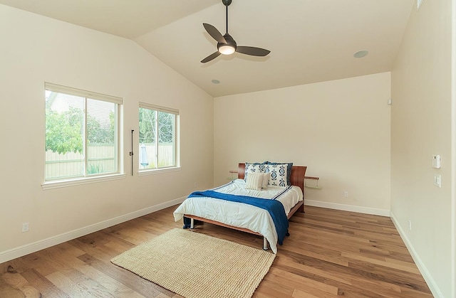 bedroom with a ceiling fan, vaulted ceiling, baseboards, and light wood-type flooring