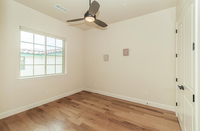 empty room featuring light wood-type flooring, visible vents, and baseboards