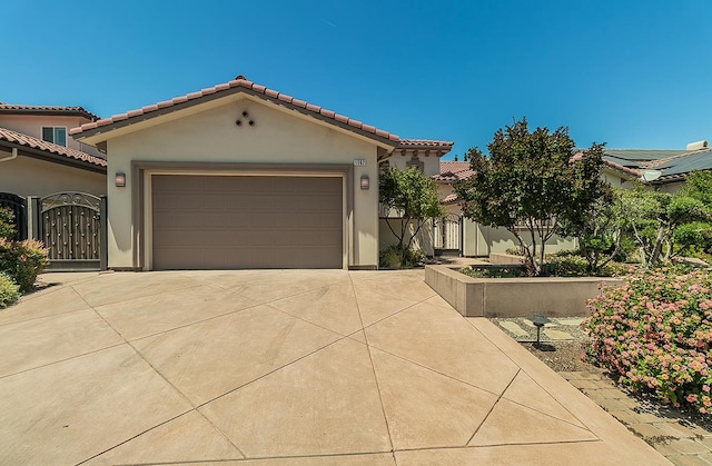 1562 N Empire Ln, Clovis, CA 93619 - mediterranean / spanish house with concrete driveway, a gate, a tile roof, and stucco siding