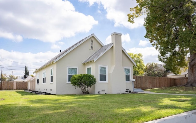 view of home's exterior with crawl space, stucco siding, a yard, and fence