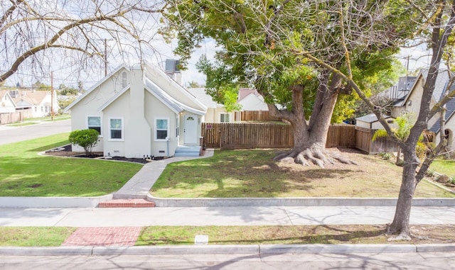 bungalow-style home featuring a front yard, fence, and stucco siding