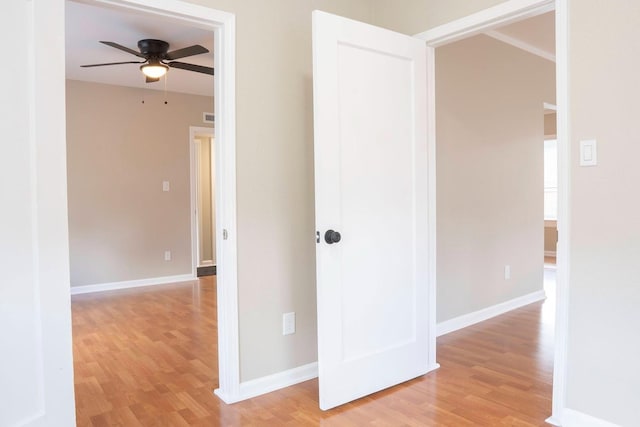 hall featuring visible vents, baseboards, and light wood-style floors