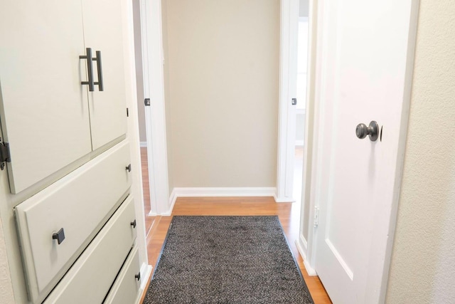 hallway featuring light wood-style floors and baseboards