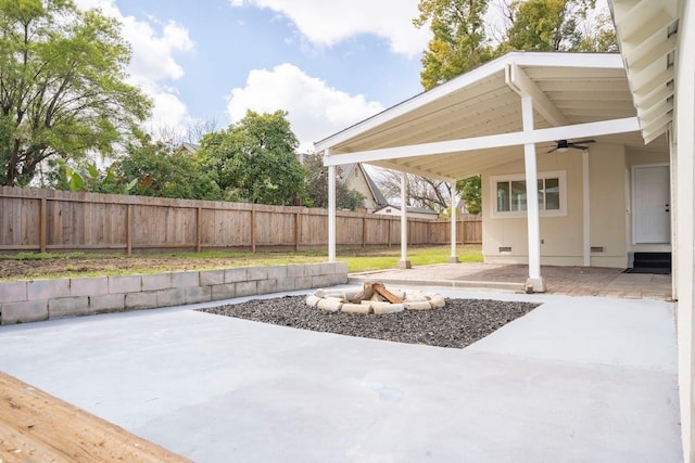 view of patio / terrace featuring a fenced backyard, a fire pit, ceiling fan, and entry steps