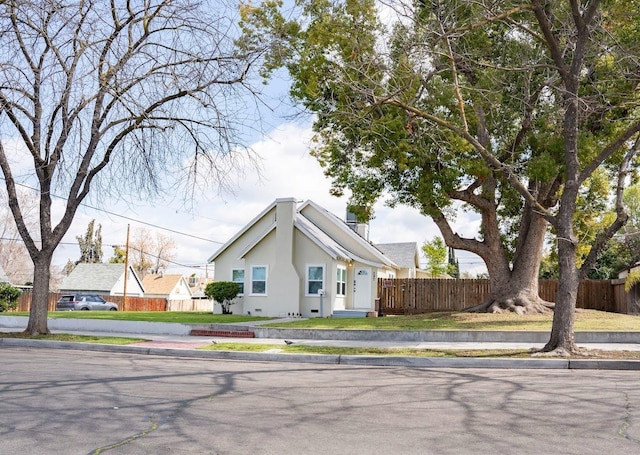 view of front facade with stucco siding and fence