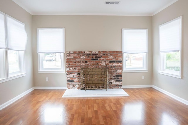 unfurnished living room with visible vents, baseboards, and wood finished floors