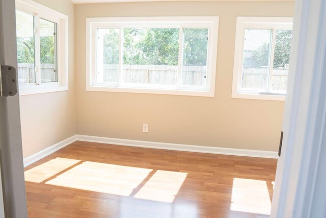 empty room featuring wood finished floors and baseboards