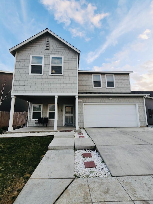 view of front facade featuring fence, a porch, concrete driveway, a front yard, and a garage