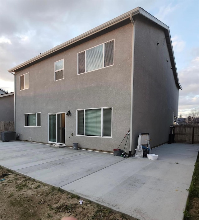 back of house featuring stucco siding, central AC, a patio, and fence