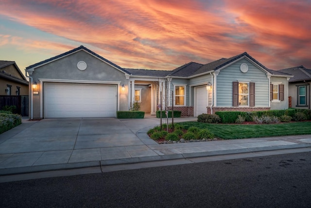 single story home with a tile roof, brick siding, a garage, and driveway