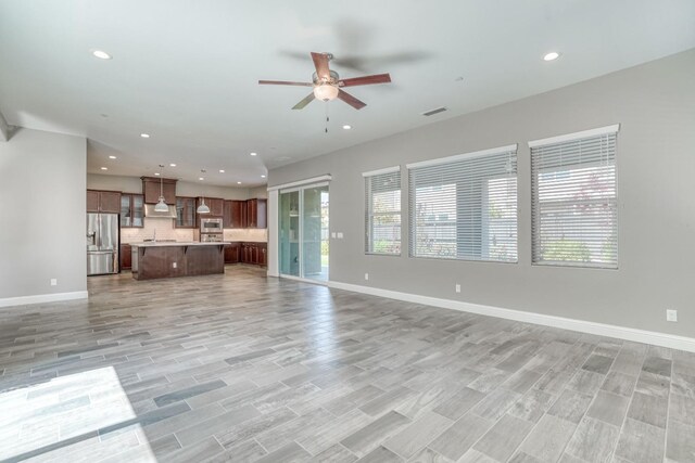 301 Pinnacle Dr W, Madera, CA 93636 - unfurnished living room featuring ceiling fan, baseboards, recessed lighting, a sink, and light wood-type flooring