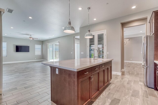 301 Pinnacle Dr W, Madera, CA 93636 - kitchen with freestanding refrigerator, a ceiling fan, wood finish floors, light stone counters, and baseboards