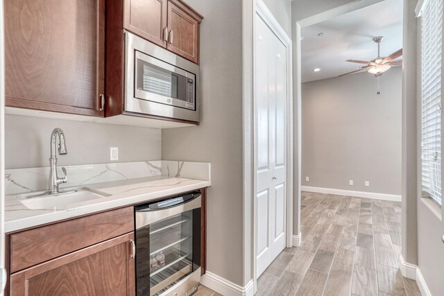 301 Pinnacle Dr W, Madera, CA 93636 - kitchen with beverage cooler, stainless steel microwave, ceiling fan, a sink, and baseboards