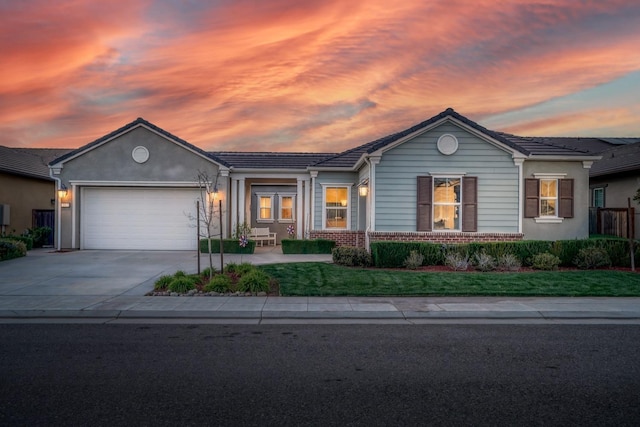 single story home with concrete driveway, an attached garage, and brick siding