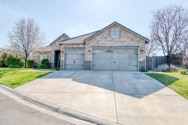 view of front of home featuring concrete driveway, an attached garage, fence, and a front yard