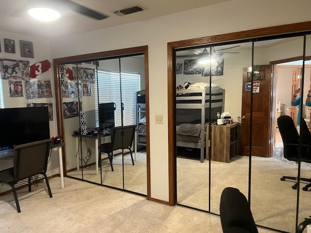 carpeted office featuring a ceiling fan and visible vents