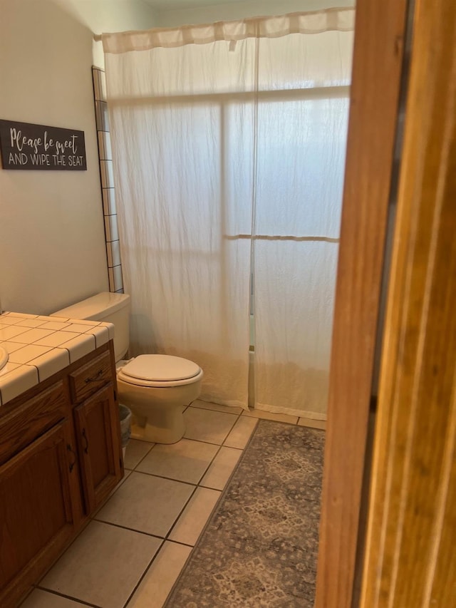 bathroom featuring a shower with shower curtain, toilet, vanity, and tile patterned flooring