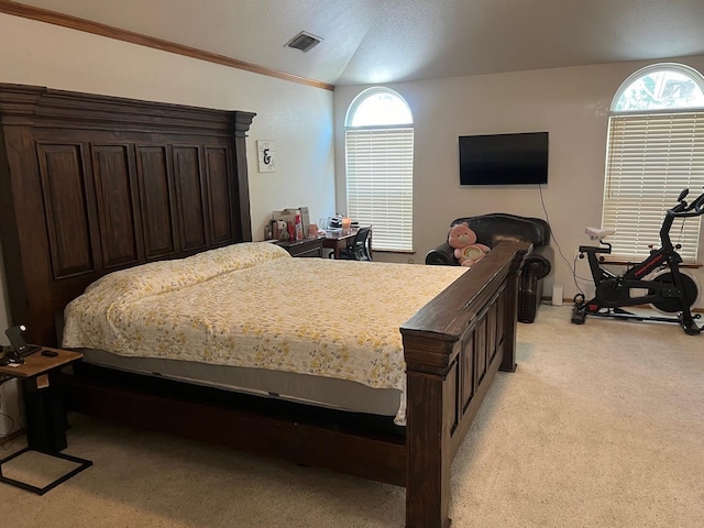 bedroom with visible vents, light colored carpet, lofted ceiling, and ornamental molding