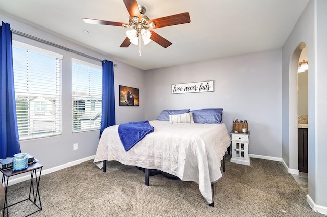 bedroom featuring baseboards, arched walkways, a ceiling fan, and carpet flooring