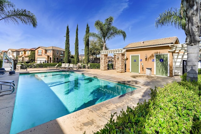 community pool with a residential view, a patio, a pergola, and fence