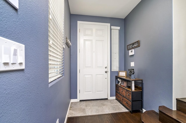 foyer featuring baseboards and wood finished floors