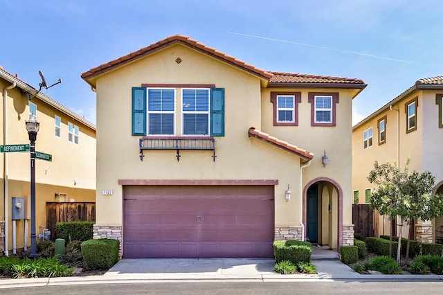 mediterranean / spanish home featuring fence, stone siding, and stucco siding