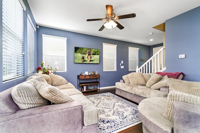 living area with stairway, baseboards, a ceiling fan, and wood finished floors