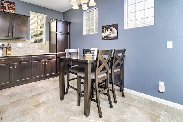 dining space featuring an inviting chandelier and baseboards