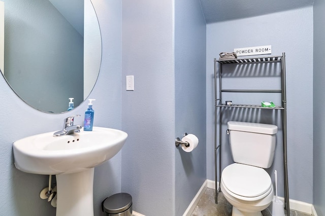 half bathroom with toilet and baseboards