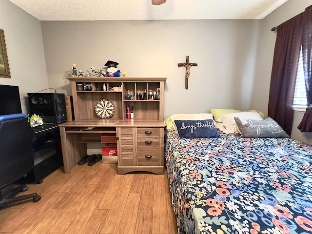 bedroom with light wood-style flooring and a textured ceiling