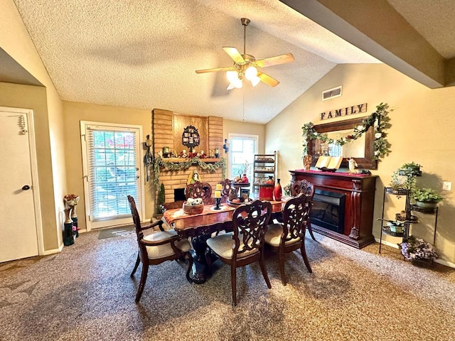 carpeted dining room featuring visible vents, a textured ceiling, a fireplace, and vaulted ceiling